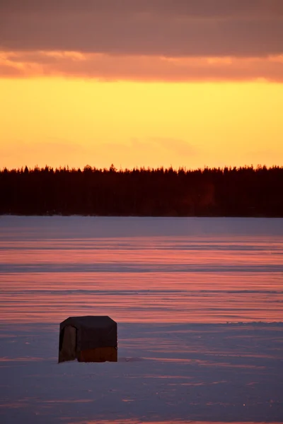 Capanna da pesca sul lago ghiacciato al tramonto — Foto Stock