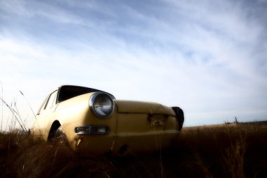 Abandoned yellow foreign car in Saskatchewab lot