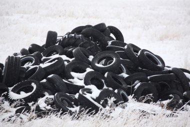 Pile of used tires in winter clipart