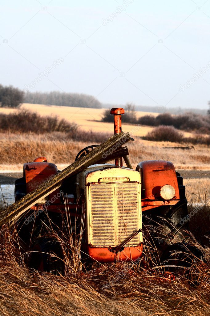Old abandoned tractor in tall vegetation