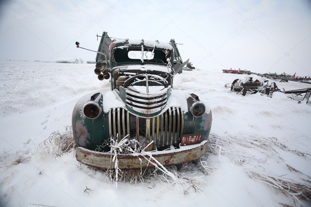 Frontend of an abandoned olf farm truck in winter