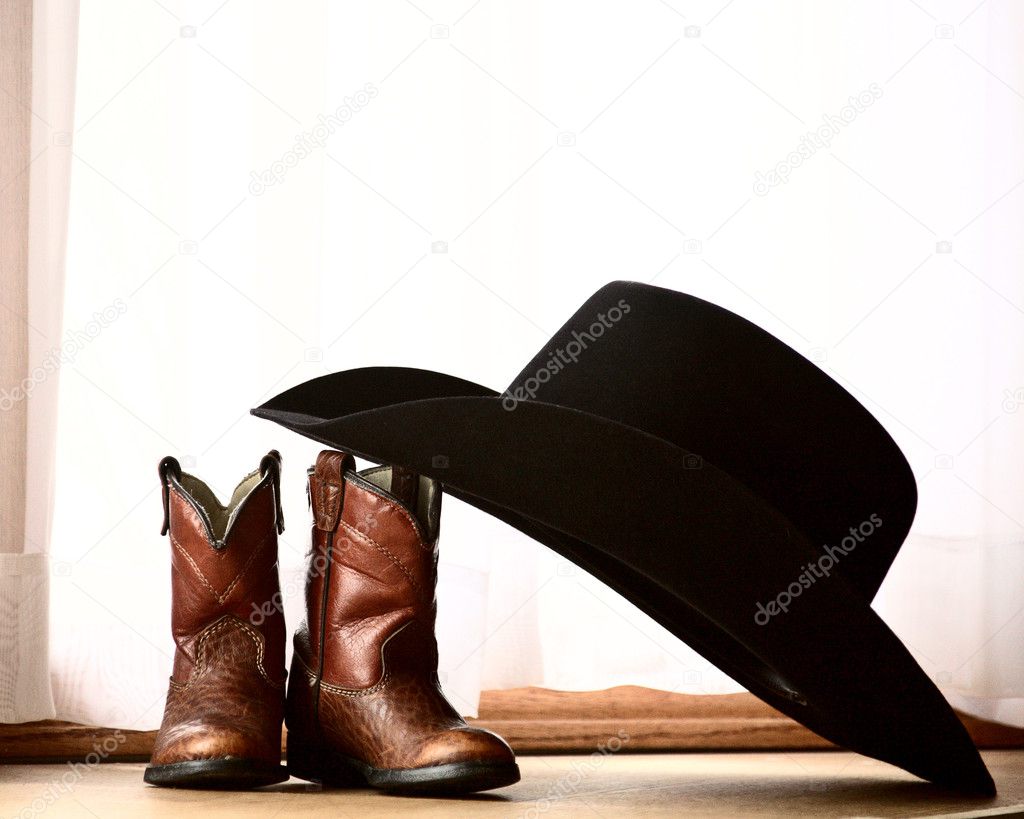 Cowboy hat leaning on small boots