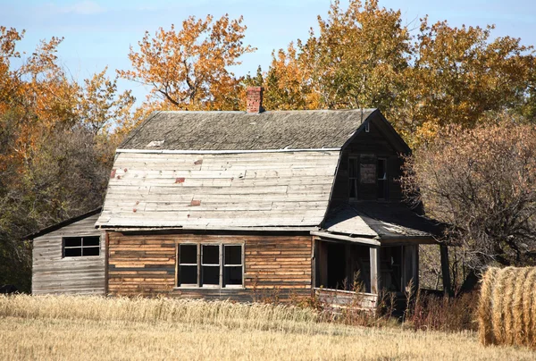 Брошенный фермерский дом с тюком сена — стоковое фото