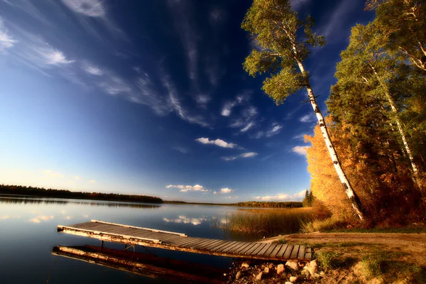 Лодка и осенние деревья вдоль озера Саскачеван — стоковое фото