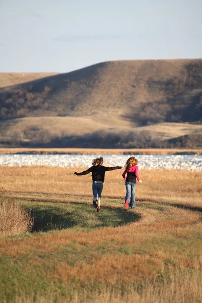 Две девушки бегут по дамбе в живописном Саскачеване — стоковое фото