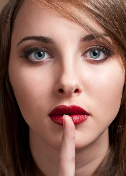 Retrato de mujer joven con el dedo cerca de los labios — Foto de Stock