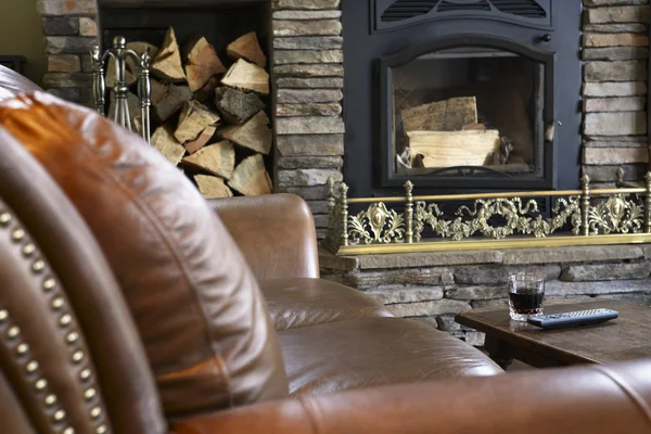 Leather sofa and unlit fireplace — Stock Photo, Image