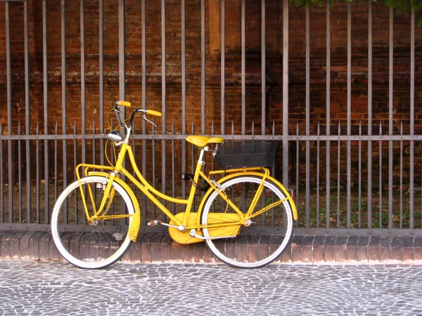 老黄自行车靠在钢栅栏 — 图库照片