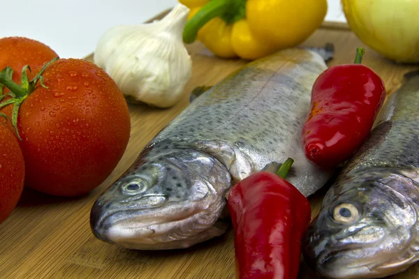 Fish (trout), peppers, tomatoes, garlic and peppers — Stock Photo, Image