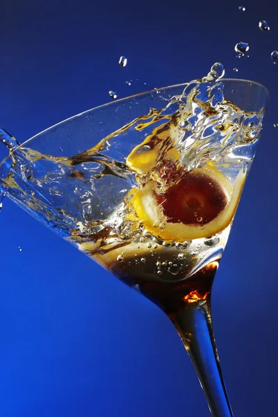 Nahaufnahme Von Oliven Die Ein Cocktailglas Vor Blauem Hintergrund Spritzen — Stockfoto