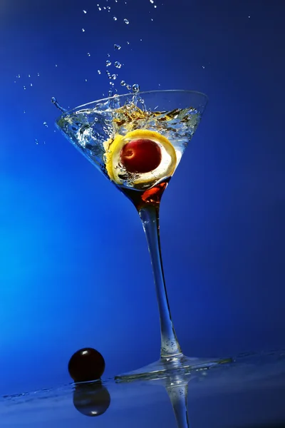 Mavi Arka Plan Üzerinde Bir Kokteyl Bardağına Sıçramasına Zeytin — Stok fotoğraf