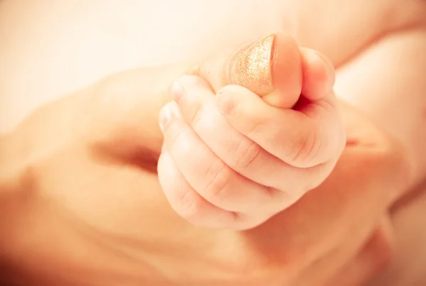 Baby's hand keeping mother finger