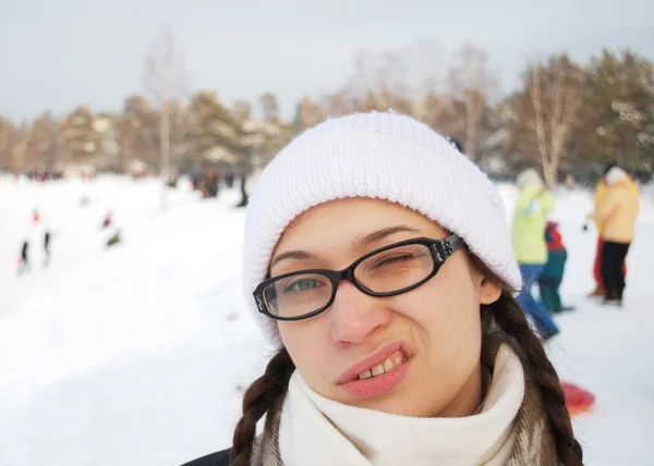Young adult woman in a white winter cap and glasses — Stock Photo, Image