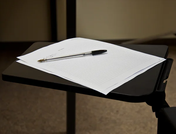 Pen and a sheet of white paper on the folding table — Stock Photo, Image