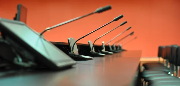 Mesa de conferencias, micrófonos y sillas de oficina — Foto de Stock