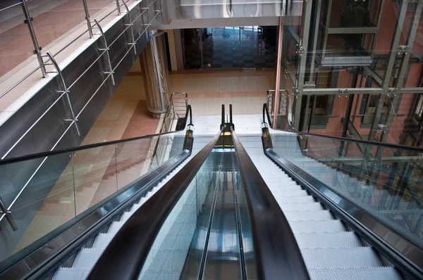 Glass elevator shafts, escalators in a modern office building — Stock Photo, Image