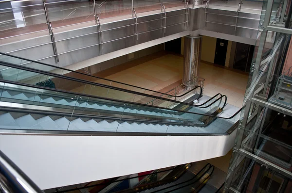玻璃电梯、 自动扶梯在一座现代化办公大楼 — 图库照片
