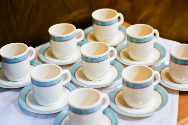 Nove xícaras de chá de porcelana branca e pires e guardanapos — Fotografia de Stock