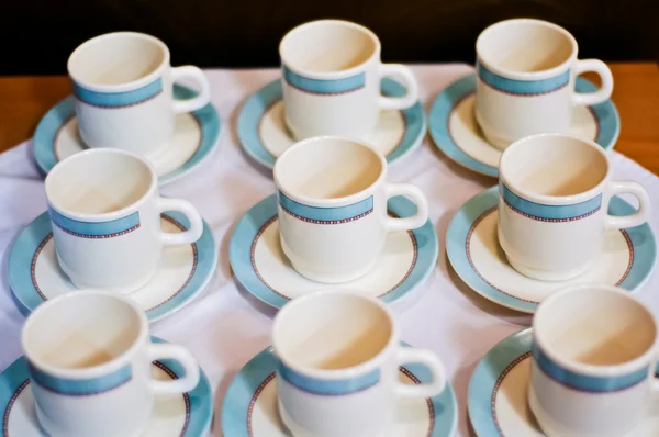 Nine white porcelain tea cups and saucers and napkins — Stock Photo, Image
