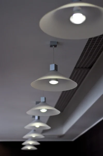 stock image Several modern chandeliers on the ceiling in the bar