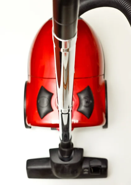 O aspirador vermelho com uma mangueira preta sobre um fundo branco — Fotografia de Stock