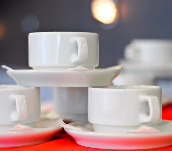 Három fehér porcelán tea csészék és csészealjak és szalvéta közelről — Stock Fotó