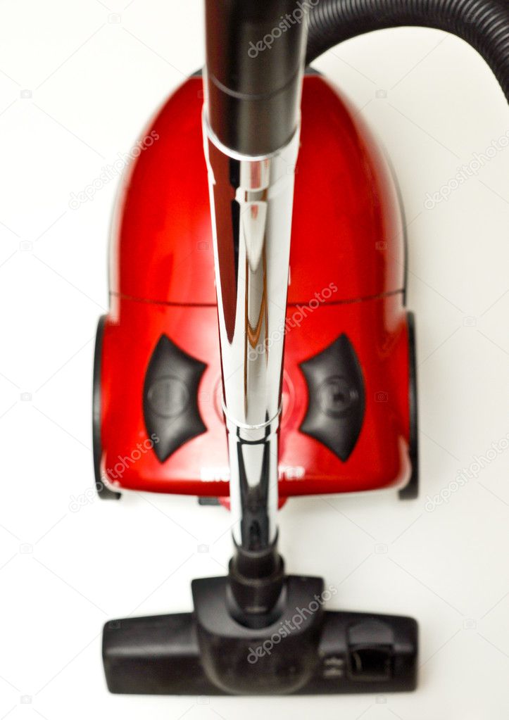 The red vacuum cleaner with a black hose on a white background