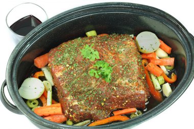 Cut pork meat with added ingredients and vegetables, ready red wine to be added and to be roasted in the oven. clipart