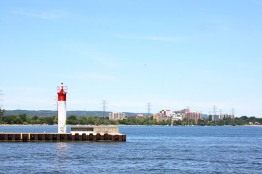 Landscape picture of shoreline of front of Burlington Ontario, where the town fronts the Lake Ontario. On front is seen auto navigation light of Burlington can clipart