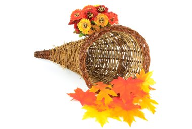 Still picture of decorative wooden basket for Thanksgiving Day and Harvest decorated with Fall leaves and flowers orientated horizontal over white. clipart