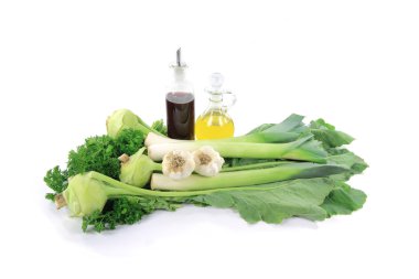 Still life picture of Green vegetables (Green Kohlrabi, Leeks), ingredients (Garlic) and seasonings (Curly Parsley, Wine Vinegar, Olive Oil) over white backgrou clipart