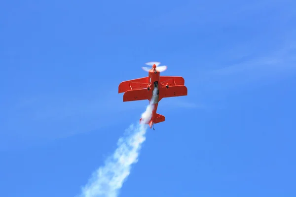 双翅膀运动飞机执行示范性特技飞行飞行与烟雾的轨道 — 图库照片