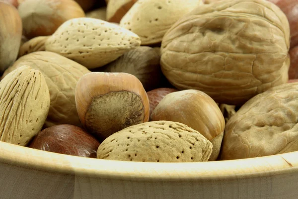 Různé ořechy v dřevěné míse. — Stock fotografie