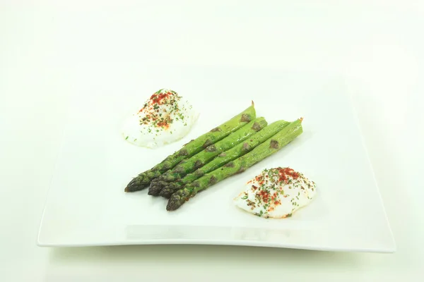 stock image Pictured plate contains Baked Asparagus Spears seasoned with Olive oil, Sea salt, Ground Black Pepper and Poached Eggs seasoned with Paprika, Black Pepper and P