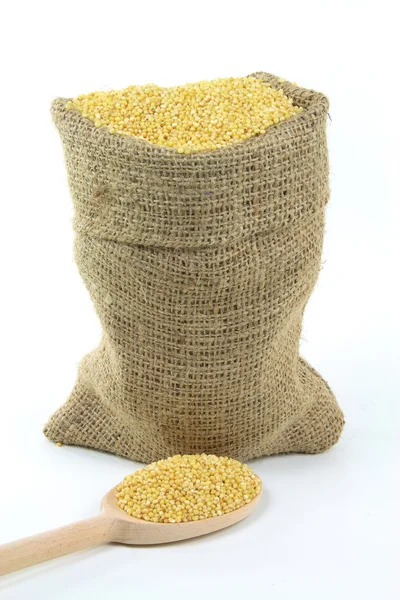 Пшеничные зерна в мешочке и на деревянной ложке . — стоковое фото