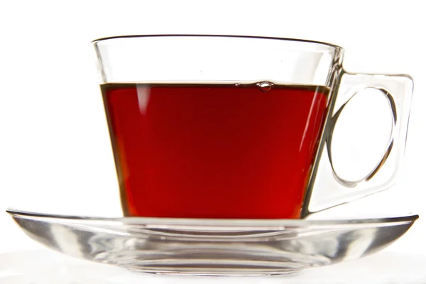 stock image A cup of tea in a clear cup on a saucer