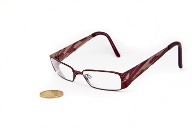 A pair of eye glasses keeping a close eye on a canadian dollar bill. clipart