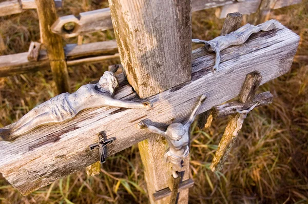 Figuras de Jesús acostadas en una vieja cruz — Foto de Stock