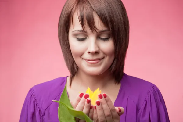 Vrouw houdt een gele tulp — Stockfoto
