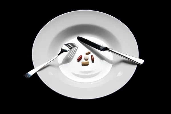 Pillen auf einem Teller Besteck isoliert — Stockfoto