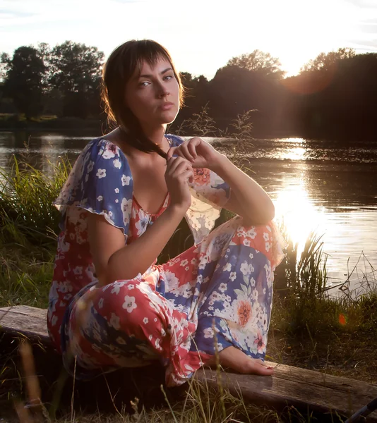 Junge Frau sitzt auf Baumstamm — Stockfoto