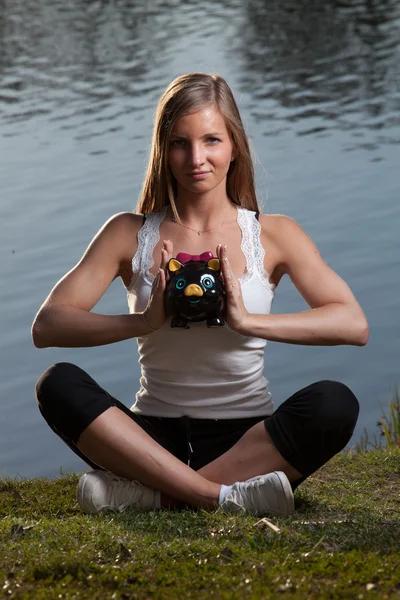 Young woman meditation piggy bank — Stock Photo, Image