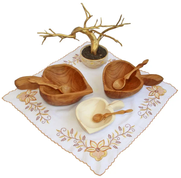 Три деревянные тарелки с ложками на вышитой салфетке и золотое дерево — стоковое фото