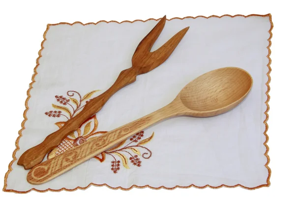 A wooden spoon and a plug on the embroidered napkin — Stock Photo, Image