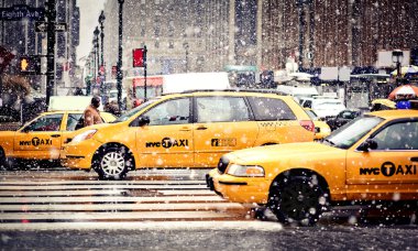 Taxi Cabs cautiously maneuvering through a blizzard in Eight Av, NYC clipart