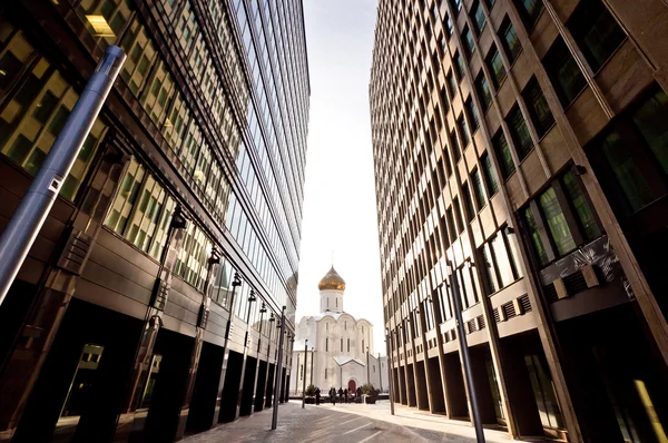 Старая русская церковь между двумя современными небоскребами — стоковое фото
