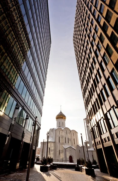 Vieille église russe entre deux gratte-ciel modernes — Photo