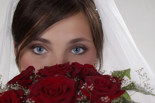 Stock image Bride in studio holding a bouquet of red roses