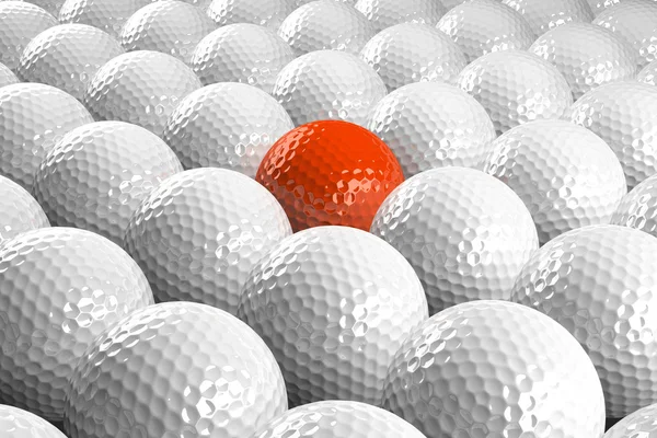 Balles de golf blanches et une orange au milieu — Photo