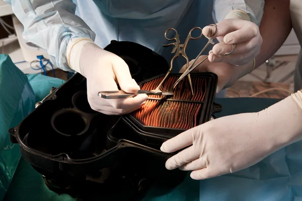 stock image Doctors in the operating room dissects motorcycle air filter